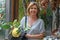 Portrait of an attractive woman with a large lemon in her hand in front of a fruit and vegetable stand