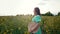 Portrait of attractive woman posing in blooming canola flowers field. Elegant girl in retro dress with straw hat