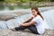 Portrait of attractive woman sitting close to waterfall of the Cijevna river. It is called Montenegrin Niagara Falls. Surroundings