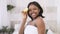 Portrait of attractive young african american woman holding lemon and kiwi halves smiling enjoying natural healthy