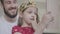 Portrait attractive young bearded father putting the crown on the head of his little girl, making her princess while the