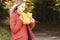 Portrait of an attractive young blonde in a red coat with a bouquet of yellow leaves in her hand. The concept of