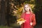 Portrait of an attractive young blonde in a red coat with a bouquet of yellow leaves in her hand. The concept of