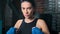 Portrait of attractive young brunette kickboxer girl hitting arm ready to fight medium close-up