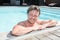 Portrait of attractive young man on edge of home swimming pool