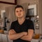 Portrait of an attractive young man with a stylish hairstyle in a fashionable black t-shirt indoors. Handsome guy enjoys the