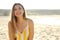 Portrait of attractive young woman enjoying summertime on the beach looking at camera