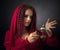 Portrait of attractive young woman in a fancy red dress with copper candlestick and burning candle