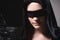 Portrait of an attractive young woman in a hood and black cape with a blindfold. Low key sexy caucasian girl justice and