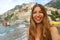 Portrait of attractive young woman in Positano City on Amalfi Coast, Italy. Blonde smiling bikini girl with Positano City