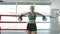 Portrait of attractive young woman in sports uniform and gloves standing in boxing ring