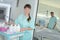 portrait auxiliary nurse with trolley outside patients room