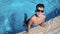 Portrait baby boy in trendy sunglasses playing splash water at swimming pool summer vacation slowmo