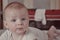 Portrait of a baby girl on the bed in bedroom. Domestic room. Cute little baby girl crawling on bed at home