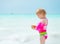 Portrait of baby girl holding shell on beach