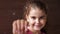 Portrait of a baby girl with a toothless smile. Shows a ripped tooth into the camera in an extended hand. Shift focus