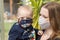 Portrait of baby and mother together with reusable protective face mask