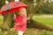 Portrait of baby with red umbrella outdoors