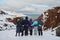 Portrait from back of warmly dressed woman in defocus standing in front of sea looking far away looking at winter rough