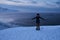 Portrait from back of warmly dressed woman in defocus standing in front of sea looking far away looking at winter rough