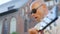 Portrait of a bald adult man in sunglasses plays guitar and sings outdoors. Close up shot.