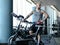 Portrait of a bald athletic man with a tattoo on his hand standing next to a exercise bike in the modern fitness club