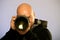 Portrait of bald male photographer with camera