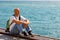 Portrait bald man on background sea. Tourist guy sitting on embankment near