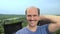 Portrait, balding young man in the countryside looking at the camera, smiling