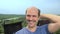 Portrait, balding young man in the countryside looking at the camera, smiling