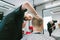 Portrait of a barber cuts a young man in a barber shop, looking intently at the client`s hairstyle. Bald professional hairdresser