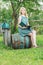 Portrait of barefoot student girl in garden with opened book