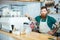 Portrait of barista standing near coffe machine in coffee shop