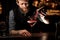 Portrait of bartender sprinkling an alcohol cocktail in glass