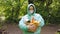 Portrait of a basket of food in the hands of a woman volunteer in protective gloves and rain coat, close-up.