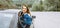 Portrait of beaming lady leaning on door of automobile. Glad female during rest in automobile