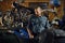 Portrait of bearded brutal biker at motorcycle in garage workshop