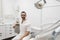 Portrait of a bearded dentist smiling at camera sitting on dentist chair