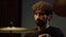 Portrait of bearded drummer performing solo on drum cymbals in recording studio.