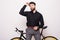 Portrait of a bearded handsome young man leaning on fixie bicycle over white background