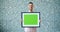 Portrait of bearded man holding green chroma key mockup picture and smiling