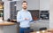 Portrait of bearded man standing with book in contemporary interior of home kitchen