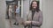 Portrait of bearded Middle Eastern man typing on laptop keyboard, looking at camera and smiling. Confident office worker