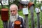 Portrait bearded old man on the background wooden farmhouse.