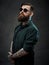 Portrait of a bearded tattooed guy wearing green shirt and sunglasses