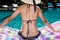 Portrait of beautifu woman relaxing in bikini and big hat in swimming pool