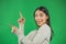 Portrait of beautiful 20s Asian woman wearing adorable dress expressing happiness pointing fingers sideways at copyspace