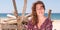 Portrait of beautiful 40-year-old brunette woman on summer sand beach driftwood in template web banner