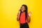 Portrait of beautiful African American woman joyful talking on mobile phone with friend on yellow background