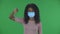 Portrait of beautiful african american young woman in medical protective face mask looking at camera and shows fingers